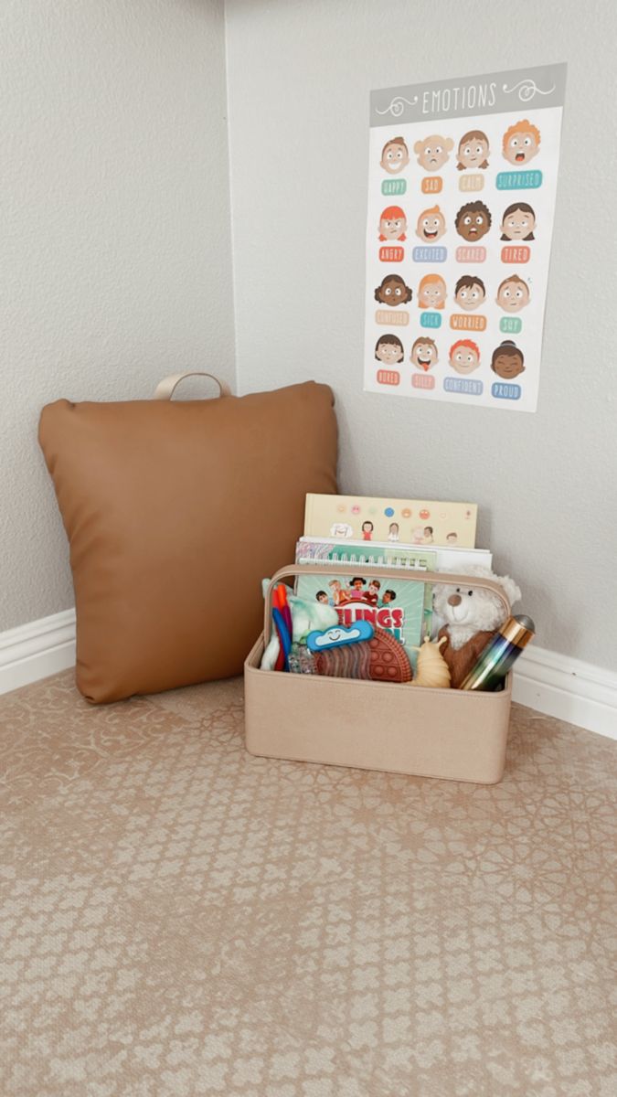 a brown pillow sitting on top of a floor next to a box filled with toys