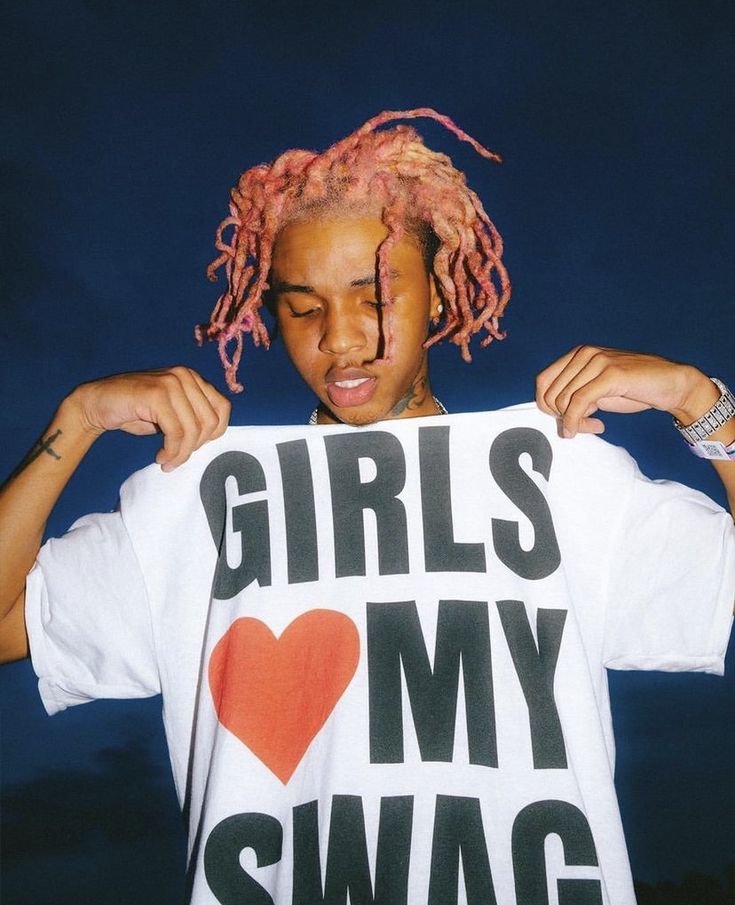 a girl with pink dreadlocks holding up a t - shirt that says girls my swag