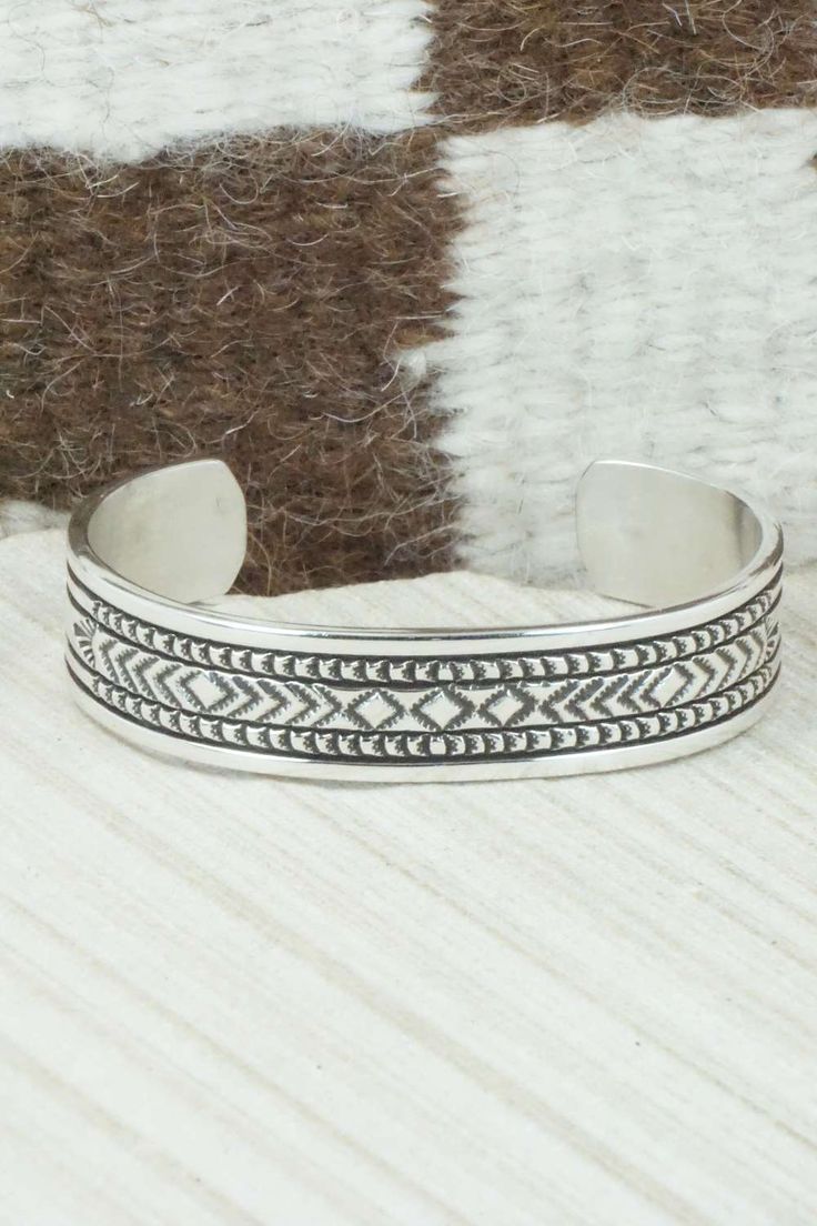 This sterling silver and bracelet was made by Navajo silversmith Bruce Morgan. The inside is signed B. Morgan and stamped sterling.Size: 5 1/4" (will fit up to a 6 3/8" wrist)Gap: 1 1/8"Width: 1/2"Free shipping on all orders! We ship with USPS and always include tracking. All orders ship within a day of payment.Returns are accepted up to 30 days after you receive your order. Just send us a message. Our shop offers cash back or store credit. The item must be returned in new condition. Nickel-free Southwestern Sterling Silver Bracelet, Artisan Sterling Silver Bracelet With Etched Details, Adjustable Silver Southwestern Bracelet, Adjustable Southwestern Sterling Silver Bracelet, Southwestern Adjustable Sterling Silver Bangle Bracelet, Adjustable Silver Southwestern Bangle, Oxidized Sterling Silver Southwestern Bracelet, Adjustable Southwestern Silver Bangle, Oxidized Finish Southwestern Sterling Silver Bracelet