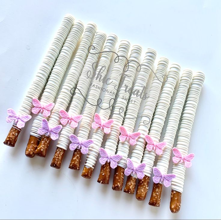 six white rolls with pink bows are lined up in a row on top of each other