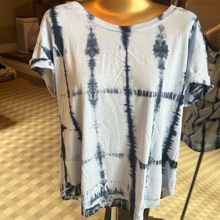 a blue and white tie - dyed shirt on a mannequin stand in a store