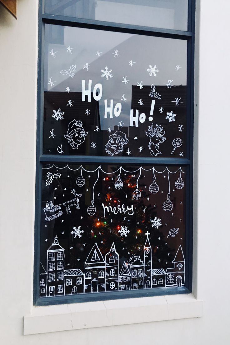 a window with christmas decorations drawn on it