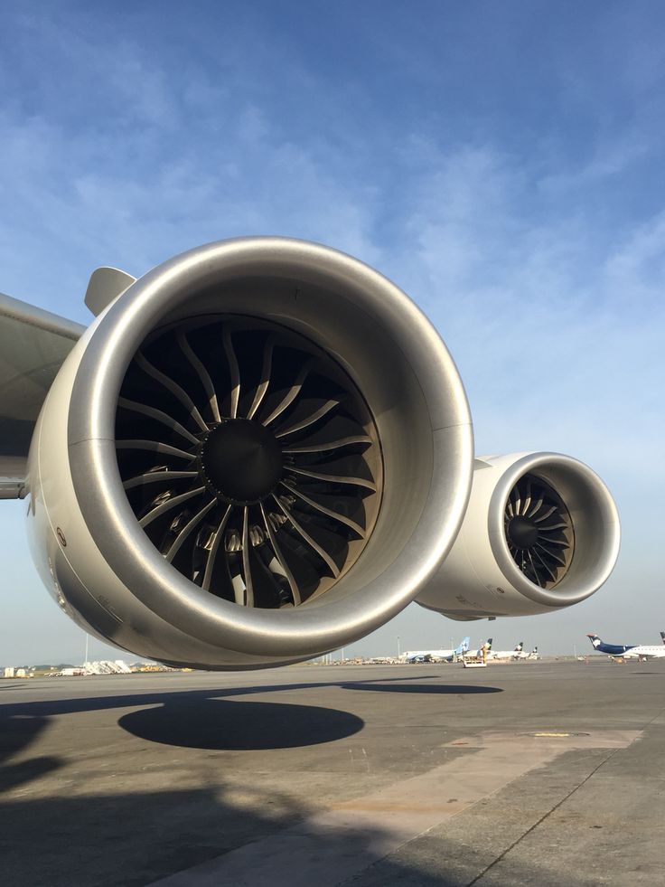 an airplane engine on the tarmac under a blue sky