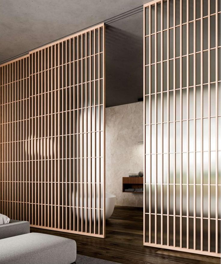 a bed sitting in a bedroom next to a wooden wall with metal bars on it