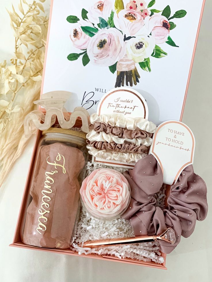 a pink gift box filled with lots of treats and confection on top of a white table