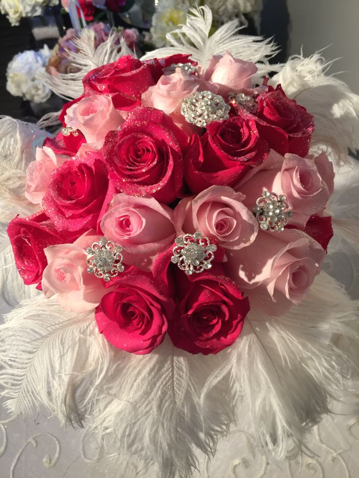 a bridal bouquet with pink roses and feathers