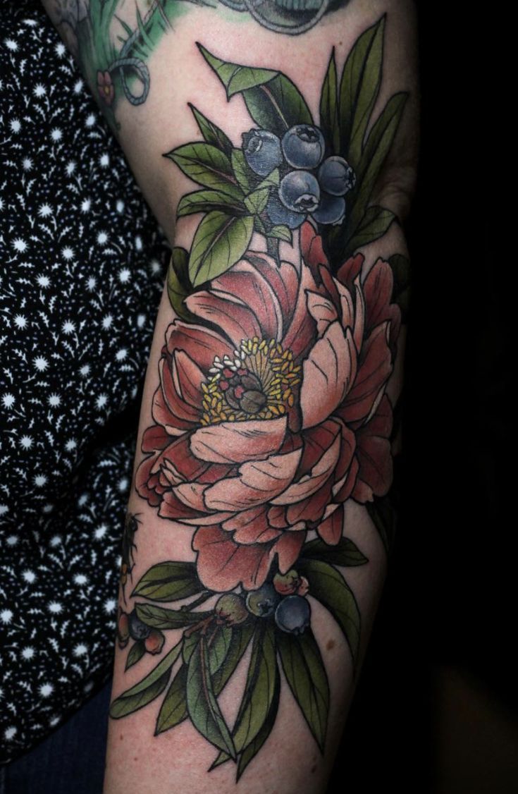 a woman with a flower tattoo on her arm