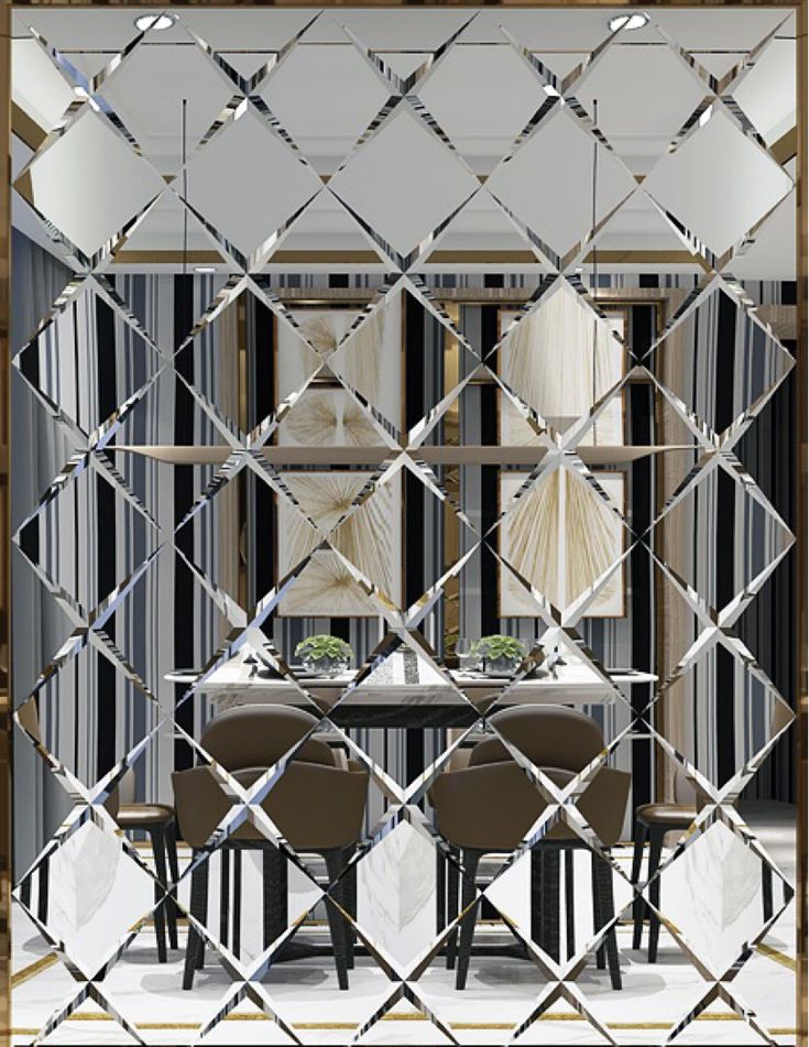 a dining room table with chairs and a mirror on the wall above it that has an abstract design