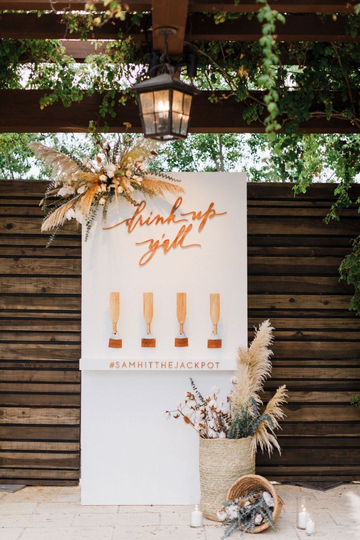 a sign that says thank you with candles and flowers in front of it on the side of a building