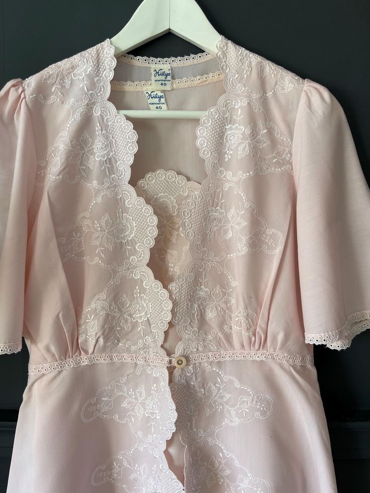 This unique set, specially designed in the 1950s, consists of a Robe and Nightgown, bringing together nostalgia and elegance. This magnificent set is made of light pink cotton Poplin Fabric, allowing you to enjoy luxury and comfort. The robe features delicate embroidery details extending to the hemline and sleeves, while the neckline of the nightgown is adorned with matching embroidery, reflecting the same elegance. Please check your measurements below. Size: Small Robe Measurements: Length: 130 cm (51.2") Chest Width: 88 cm (34.6") Waist Width: 76 cm (29.9") Nightgown Measurements: Length: 129 cm (50.8") Chest Width: 90 cm (35.4") Waist Width: 86 cm (33.9") This unique and elegant set is a perfect choice for brides who love vintage style. It can also be a wonderful gift for wedding prepar Vintage Nightgown For Wedding Night, Vintage Pink Sleepwear, Vintage Wedding Sleepwear With Lace Trim, Fitted Vintage Sleepwear With Lace Trim, Vintage Pink Sleepwear For Wedding, Vintage Pink Sleepwear For Wedding Night, Vintage Lace Wedding Sleepwear, Vintage Pink Wedding Sleepwear, Vintage Lace Nightgown For Sleep