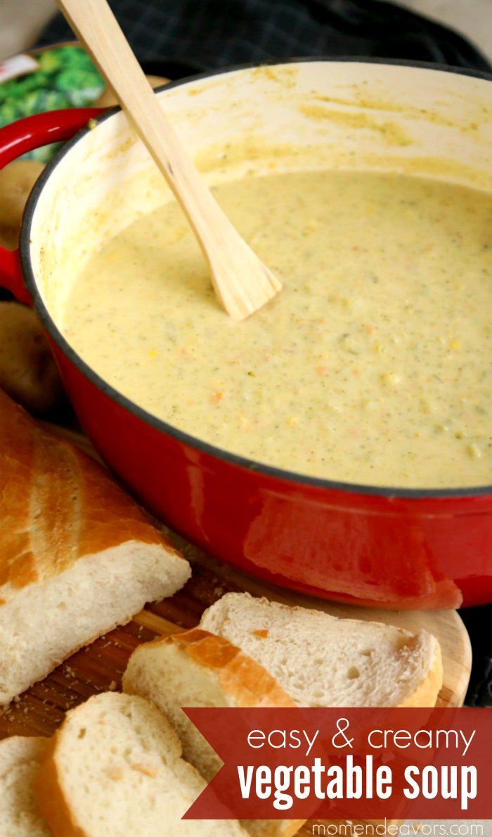 a red pot filled with soup next to sliced bread