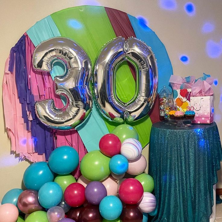 balloons and streamers are on the table for an 30th birthday party