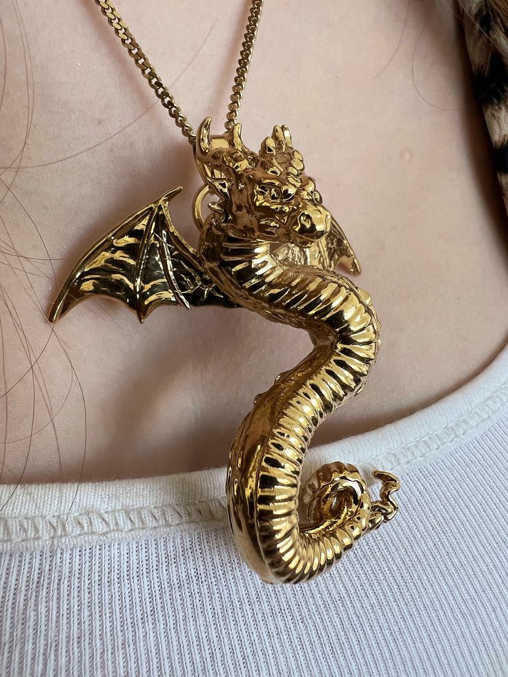 "Gold-Plated Dragon Pendant Necklace  Introducing our exclusive Gold-Plated Dragon Pendant Necklace, a perfect blend of mythical elegance and modern craftsmanship. This unique necklace showcases a meticulously designed dragon pendant, 3D printed in resin and beautifully gold-plated. Ideal for both men and women, it embodies a gothic charm that makes a bold statement. Handcrafted with precision, it's more than just a piece of jewelry; it's a wearable art piece that captures the imagination. Whether it's a special gift for him or her, or a personal treat, this dragon necklace is sure to enchant anyone who appreciates fantasy and style. Embrace the allure of the mythical dragon with this stunning, versatile piece. ➵ Handmade item to order ❤ ➵ Finish: 18k Gold, Silver Or 18k Rose Gold ➵ Chain: Spiritual Gold Jewelry With Dragon Design, Symbolic Gold Dragon Jewelry, Symbolic Gold Jewelry With Dragon Design, Metal Dragon Design Jewelry Gift, Metal Jewelry With Dragon Design As Gift, Metal Jewelry With Dragon Design For Gift, Elegant Dragon Design Necklace As A Gift, Elegant Dragon Design Necklace Gift, Elegant Dragon Design Necklace As Gift