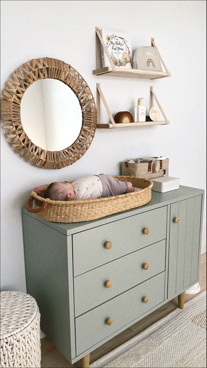 a baby sleeping in a crib next to a wall mounted mirror and shelf above it