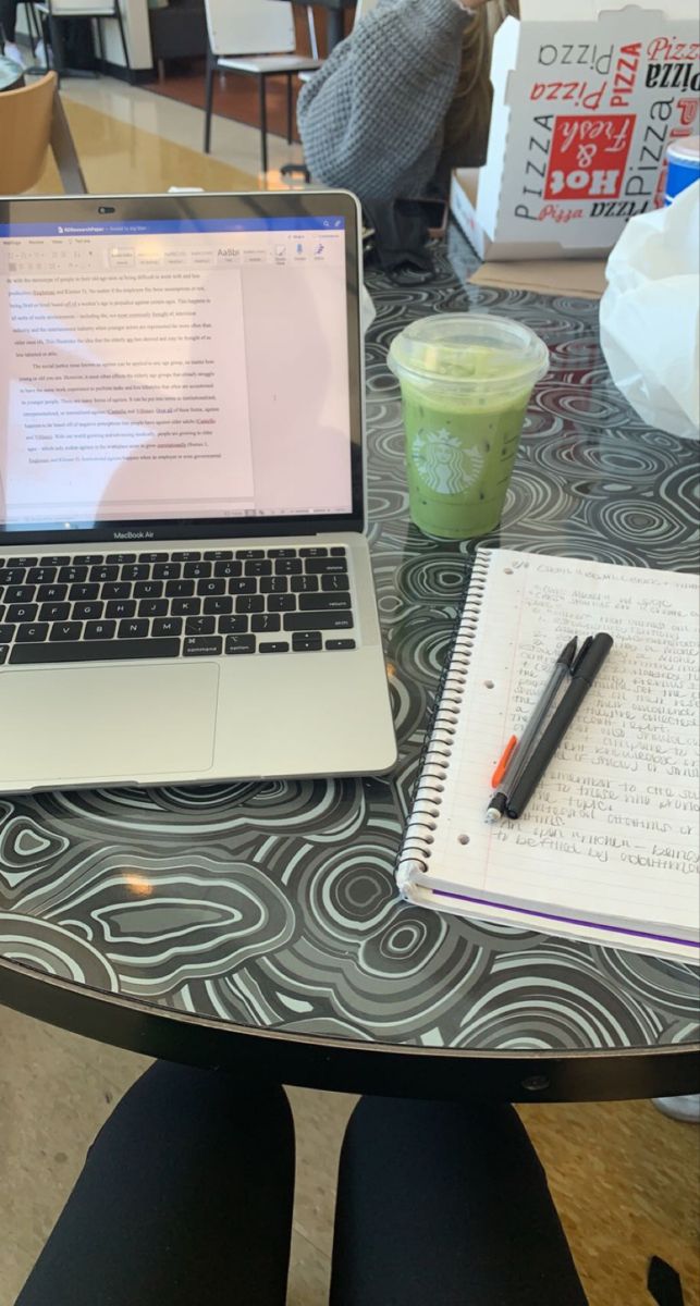 an open laptop computer sitting on top of a table next to a cup of coffee