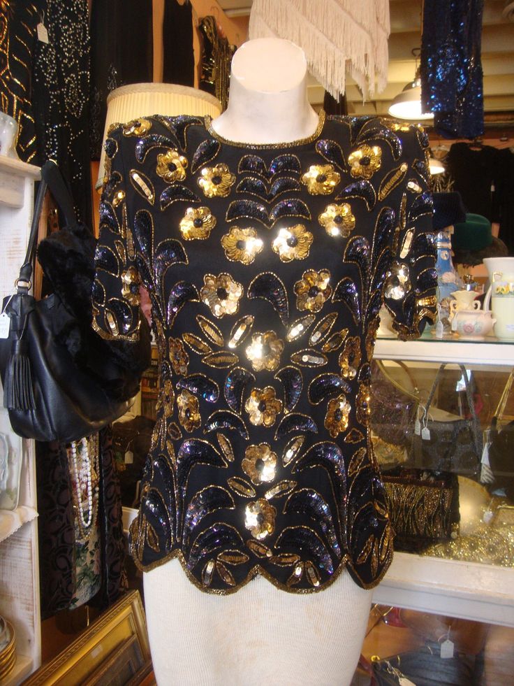 "This is a vintage beaded and sequin silk top from the 1980's or 1990's. The label is from Stenay, marked size medium.   It features a vivid floral pattern in black and gold beads and sequins.  This top opens down the back with a well working zipper.  This top is in excellent condition, just a couple of beads missing at the very bottom row, but not noticable.  Lined, with removable shoulder pads.  Comes from a smoke free home. Measurements:  Bust:  36\"   Waist: 30\"   Hip:  37\"   Across Shoulder:  16\"    Sleeve Length: 10.5\"     Length from Shoulder:  23\"  Please ask me any questions you may have before buying as this is a final sale. Please know your measurements and allow for movement.   I ship within 3 business days of cleared payment, usually sooner. If you need something quickly, Silk Embellished Party Top, Glamorous Beaded Party Blouse, Vintage Embellished Evening Blouse, Silk Party Tops With Sequins, Gold Beaded Evening Tops, Vintage Embellished Tops For Night Out, Vintage Beaded Evening Tops, Vintage Formal Top With Sequins, Vintage Formal Tops With Sequins