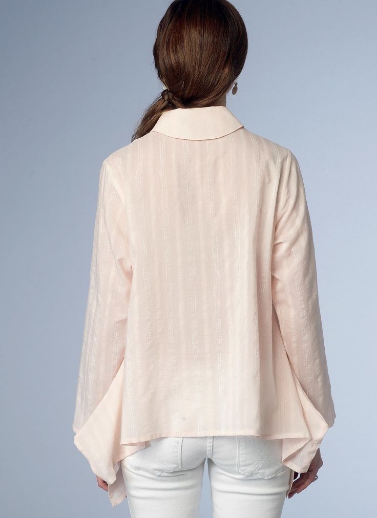 a woman in white jeans and a pink shirt is looking down at the back of her jacket