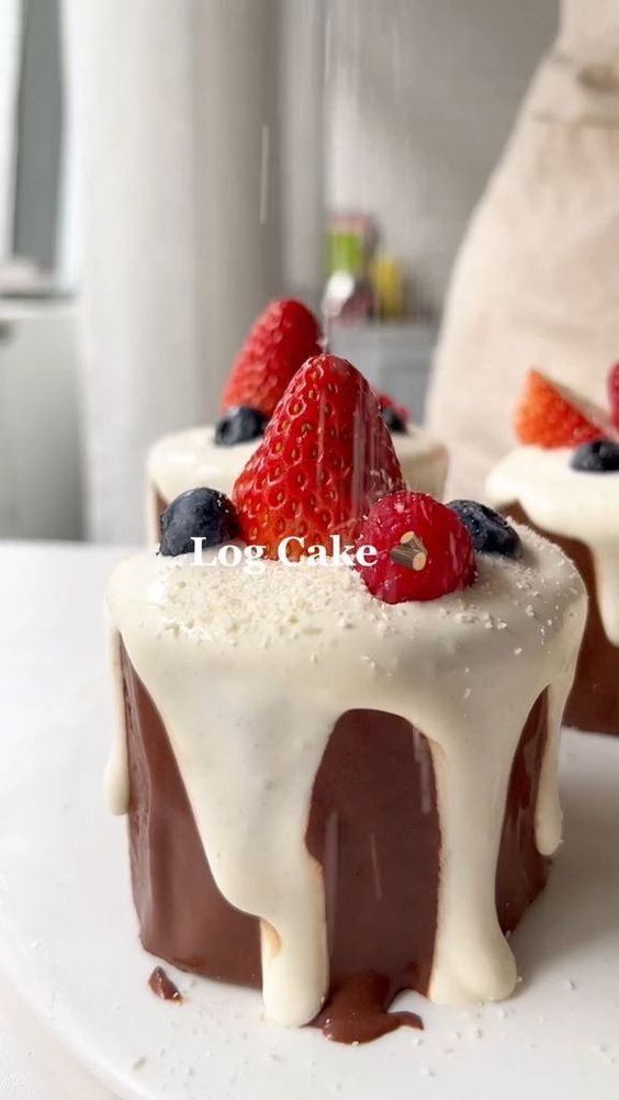 two desserts on a white plate with strawberries and chocolate