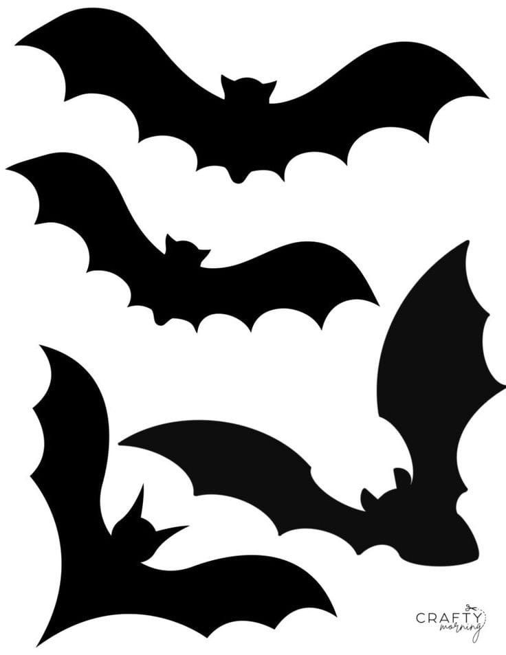 three black bats flying in the sky