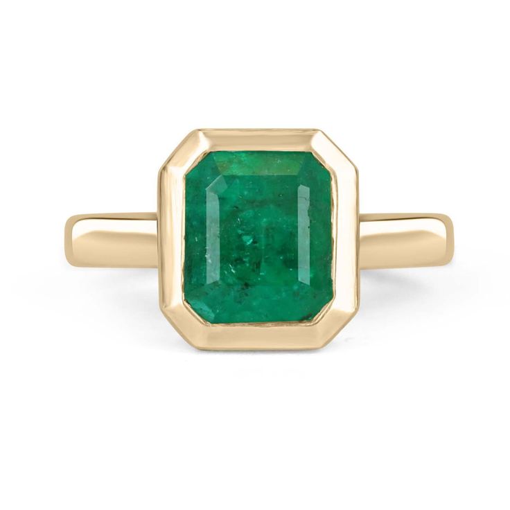 a gold ring with an emerald stone in the center