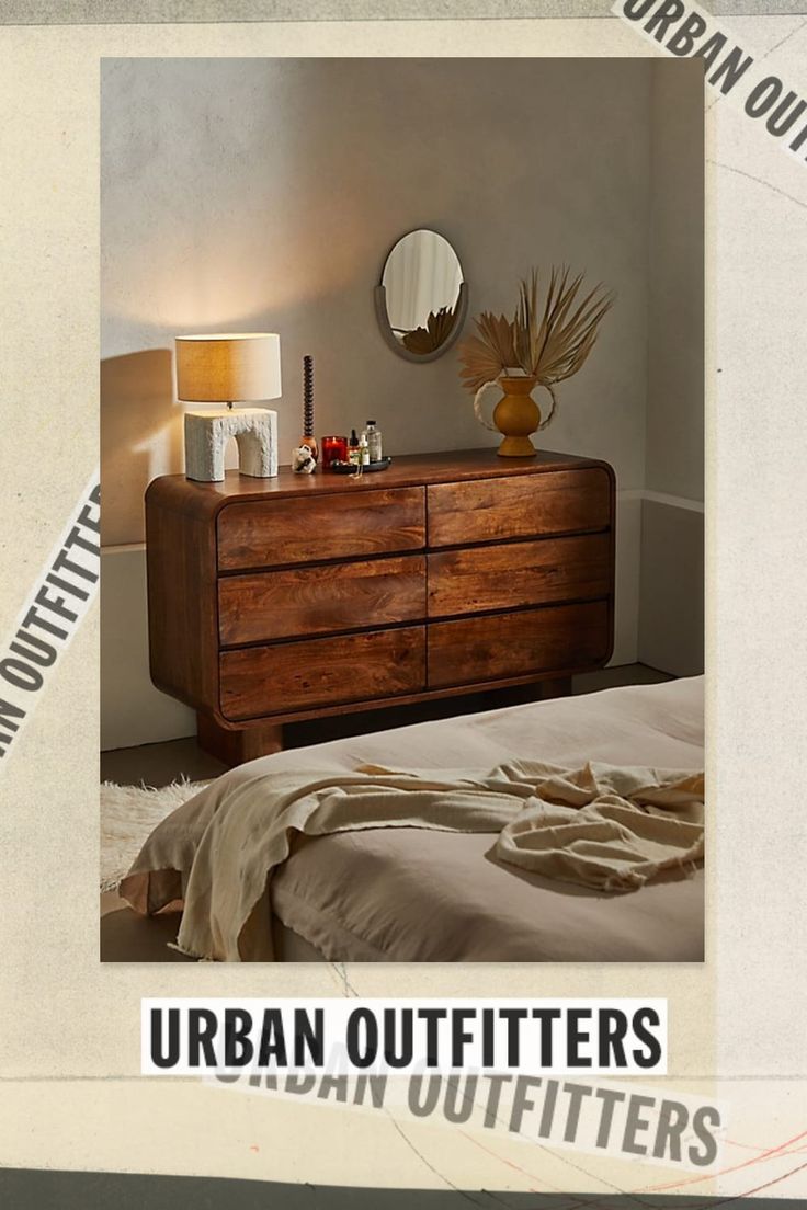 an image of a bedroom setting with a dresser and mirror on the wall above it