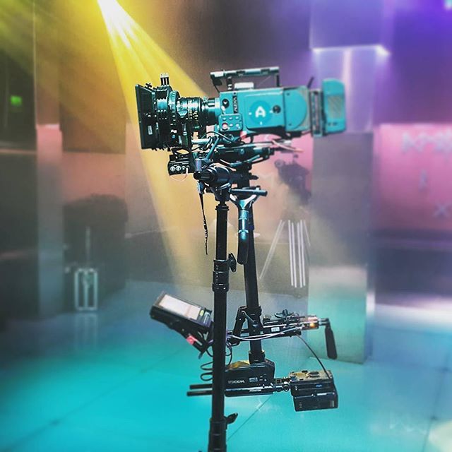 a camera is set up on a tripod in front of a stage with lights