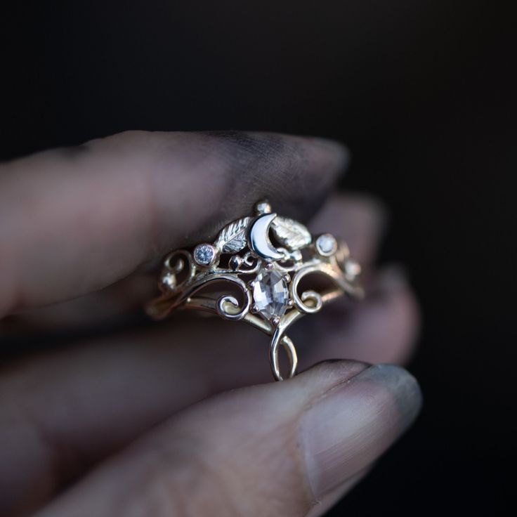 a close up of a person's hand holding a ring with flowers on it