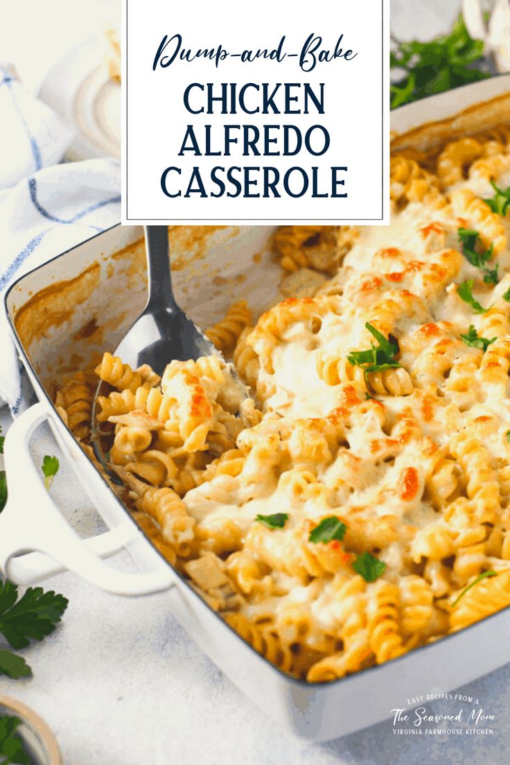 chicken alfredo casserole in a white dish with a serving spoon and parsley on the side