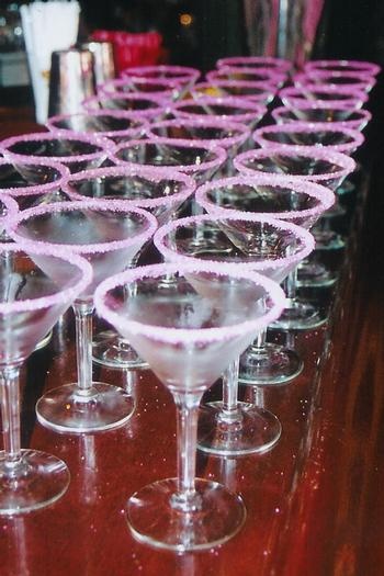 there are many wine glasses lined up on the bar top, ready to be served