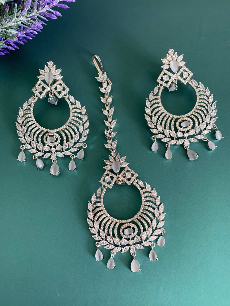 American diamond chandbali style earring with Tikka. Push back , light weight earring is about 3 inch long and Tikka 21/2. Silver Chandbali Tikka With Stone Work, Hand Set Chandbali Earrings For Reception, Festive Bollywood Chandbalis With Cubic Zirconia, Festive Hand Set Cubic Zirconia Chandbalis, Traditional Chandelier Earrings With Cubic Zirconia, Silver Chandbali Chandelier Earrings With Stone Work, Hand Set Diamond Chandbali Chandelier Earrings, Diamond Chandbali Chandelier Earrings For Reception, Silver Chandbali Tikka With Intricate Design