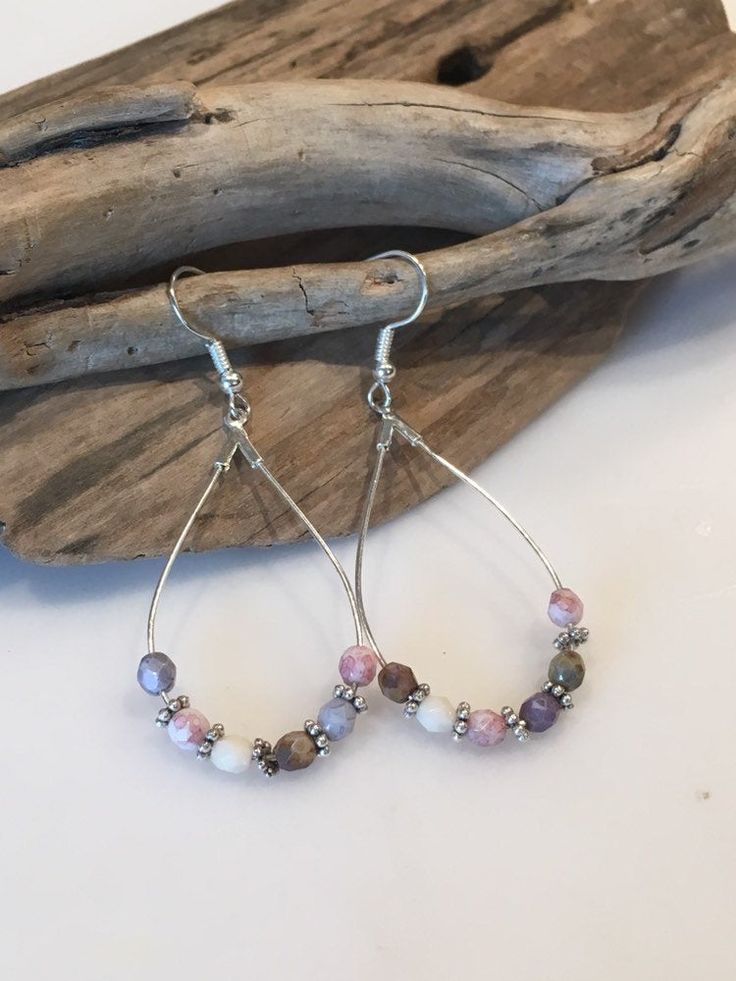 These beautiful earrings have a fun boho style! Made with Silver Teardrop hoop wires with gorgeous 6mm Faceted gemstones and gorgeous silver spacers. The earring itself measures approximately 2 inches in length by one inch wide. The ear wires are lead and nickel free. Colors of pale blues, lavender,pink, grays and cream.. Beautiful statement earrings that can be dressed up or down and worn throughout the year! Your Boho style earrings will come packaged in a pretty gift box, ready for giving or Bohemian Teardrop Hoop Earrings With Ear Wire, Bohemian Sterling Silver Teardrop Earrings, Silver Teardrop Beaded Earrings Bohemian Style, Adjustable Wire Wrapped Bohemian Teardrop Earrings, Bohemian Adjustable Wire Wrapped Teardrop Earrings, Bohemian Silver Teardrop Beaded Earrings, Bohemian Sterling Silver Teardrop Beaded Earrings, Bohemian Teardrop Beaded Earrings Nickel Free, Bohemian Teardrop Nickel Free Hoop Earrings