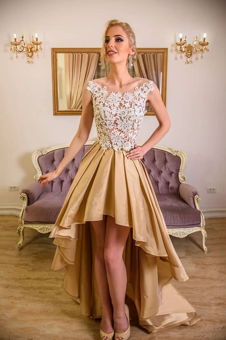 a woman standing in front of a couch wearing a dress