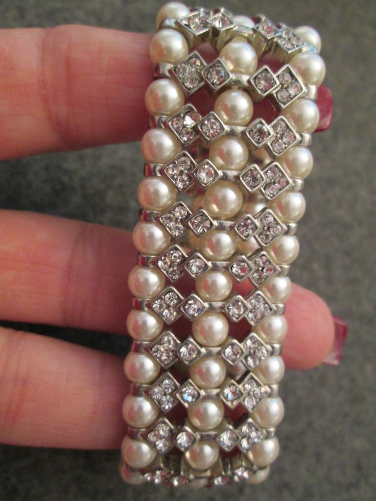 "This exquisite bracelet is from the 70's, new old stock, never worn. believe it or not, this is a stretch bracelet, although it looks so elegant and expensive! High quality costume jewelry at its finest! It measures 1 1/8\" wide, and is about 2 1/2\" across, but of course it stretches to fit almost any average size wrist comfortably. The intricacies of the design are so beautiful, and the rhinestones just sparkle! The faux pearls are of a lustrous off white color. Low pricing. **Please check ou Luxury Pearl White Bracelets For Gifts, Pearl Bracelets For Party, Pearl Embellished Party Bracelet, Vintage Pearl Bracelets For Parties, Silver Crystal Pearl Bracelet For Party, Party Jewelry With Pearl Jubilee Bracelet, Pearl Jubilee Bracelet Jewelry For Party, Elegant Jeweled Beaded Bracelets For Weddings, Pearl Bangle Bracelet For Party