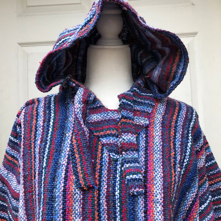 This Authentic Mexican Baja Hoodie is perfect for those crisp fall days and cool summer nights.featuring a generous hood, wide neck with ties and a front pouch pocket. Made from a cotton acrylic blend for a durable rustic exterior with a soft, cozy brush interior. MADE IN MEXICO By: Mexican Artisans For: Unisex Size: X-Large Color: blue | multi Details: 100% Acrylic Front pouch pocket Hoodie Measurements: Shoulder to shoulder: 26.5 Arm length: 21.5" Bust: 22.5 hem: 25" All hoodies are measured l Blue Hooded Tops For Beach, Blue Hooded Tops For The Beach, Blue Hooded Beach Tops, Blue Hooded Top For Beach, Long Sleeve Hoodie For Beach In Fall, Casual Hoodie For Beach In Fall, Casual Beach Hoodie For Fall, Casual Fall Beach Hoodie, Oversized Multicolor Hooded Sweater