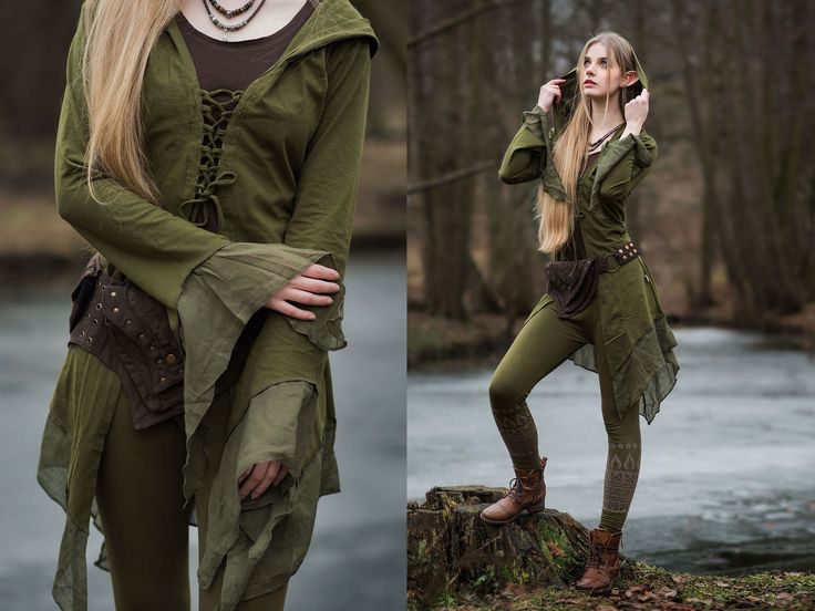 a woman dressed in green is standing on a log and talking on her cell phone