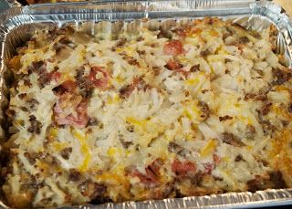 a casserole dish with meat, cheese and onions in it on tin foil