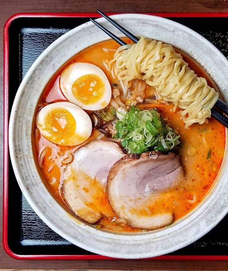 a bowl of ramen with noodles, hard boiled eggs and meat