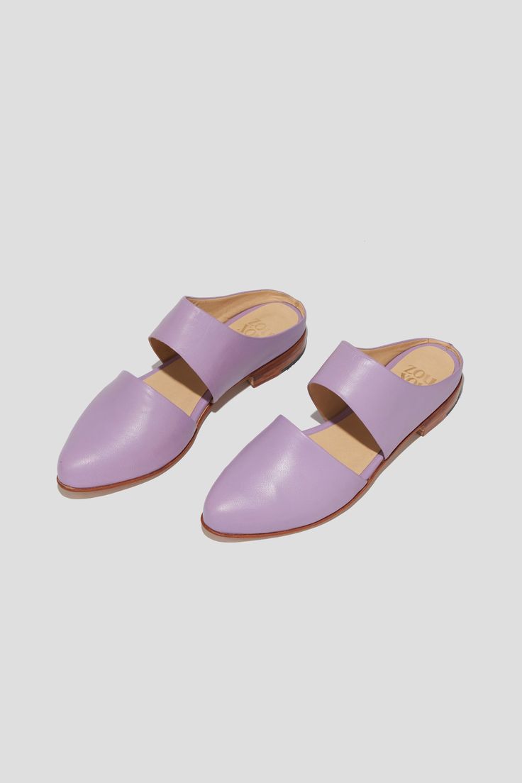 The mule is ZX’s perennial flat, inspired by traditional babouche slippers. With its sleek cut-out upper and almond shaped toe, this style makes feeling comfortable and pulled-together an easy task for days filled with lots of activity. This pair is crafted from vibrant lilac kidskin. Style yours with statement pants for a chic party look. Who it’s for: The woman with refined style who likes to go places by foot. Kidskin leather upper and undyed vegetable-tanned leather lining. Leather sole and stacked heel. Handmade in Argentina. Spring Leather Sole Slip-on Flats, Chic Almond Toe Slippers For Spring, Summer Pointed Toe Clogs With Leather Sole, Spring Clogs With Leather Sole And Pointed Toe, Spring Flat Slip-ons With Leather Footbed, Pointed Toe Clogs With Leather Sole For Spring, Leather Sole Clogs With Pointed Toe For Spring, Modern Spring Slip-ons With Leather Footbed, Modern Leather Footbed Slip-ons For Spring