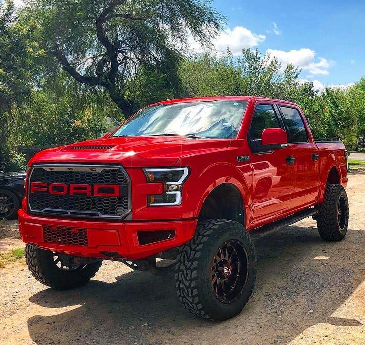 a red truck is parked in the dirt