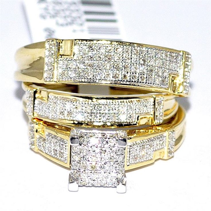 three gold rings with white diamonds on top of each other and one has a price tag in the background