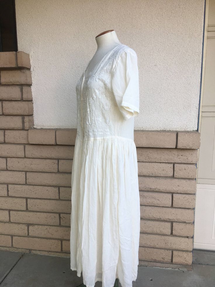 "Vintage 1980's cotton India dress! Love the unique cage-like back! Light and airy loose fitting style Creamy off white cotton linen with a gauze skirt lining Shirt waist style with intricate bodice embroidery Label: Sometimes Made in India Fabric: cotton, viscose, linen Size: labeled large; please check measurements for an accurate fit Excellent vintage condition with a few light spots on the skirt lining. Dress was measured while lying flat across the front seam to seam: Underarm to underarm - Cream Lined Vintage Dress For Summer, Cream Cottagecore Vintage Dress For Summer, White Cottagecore Vintage Dress For Summer, Cottagecore Cream Vintage Dress For Summer, Summer Vintage Dress In White For Daywear, Summer Vintage White Dress For Daywear, White Cotton Vintage Summer Dress, Cream Vintage Dress For Summer Daywear, White Cotton Vintage Dress For Summer