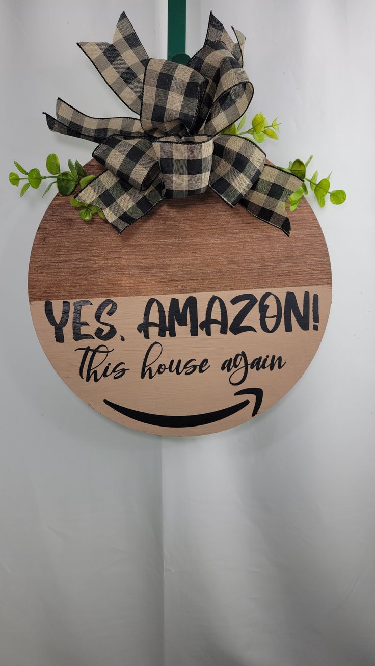 a wooden sign that says yes amazon this house is open with a bow on it