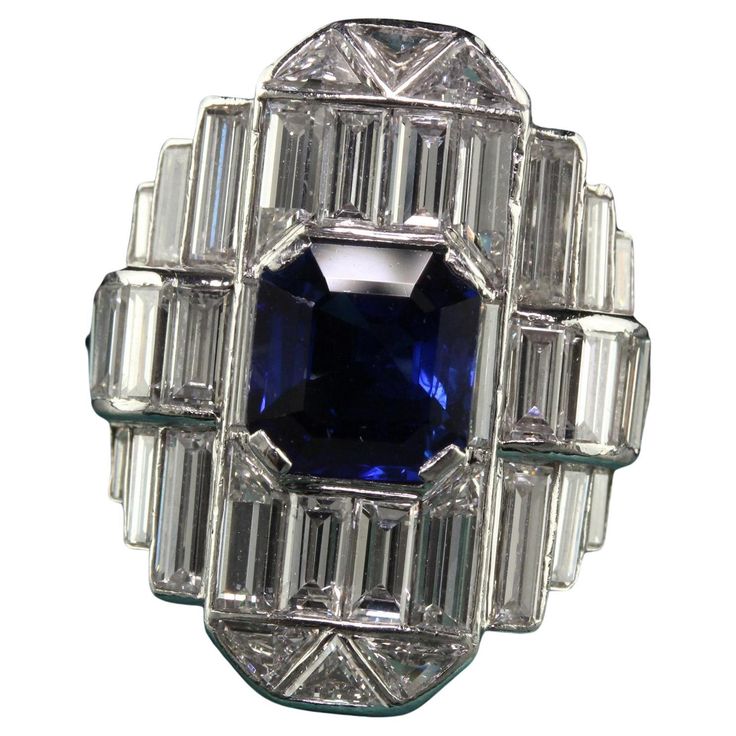 Beautiful Vintage Art Deco Platinum Baguette Diamond and Sapphire Cocktail Ring - GIA. This gorgeous Art Deco cocktail ring is crafted in platinum. The center holds a natural royal blue sapphire that has a GIA report and has white baguette cut diamonds and trillion cut diamonds set all of the top. The ring looks like a sheet of mirror and extremely sparkly! The ring is in great condition and has a serial number inside the shank. This is a remarkable ring and very rare to come by! Item #R1733 Metal: Platinum Weight: 11 Grams Size: 5 3/4 Diamonds: Approximately 4.5 cts Color: H Clarity: VS2 Sapphire: 1.87 ct - GIA # 1182009392 Measurements: Top of the ring measures 21.9 mm wide and band measures 1.75 mm wide. Measurements off the finger: 7.44 mm high Layaway: For your convenience, we will be Antique Rings 1stdibs, Wide Band Diamond And Sapphire Rings, Vintage Jewelry Rings 1stdibs, Art Deco Cocktail, Sapphire Cocktail Ring, Cocktail Art, Jewels Rings, Art Deco Diamond, Gorgeous Art