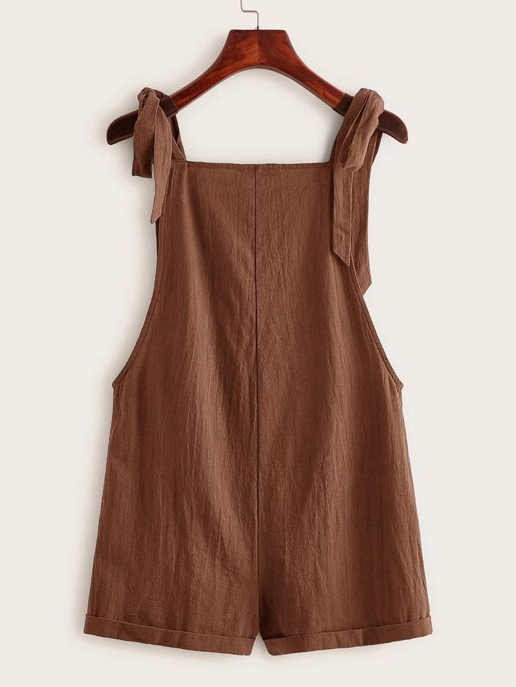 This Pocket Patched Pinafore Romper is the perfect addition to any wardrobe! This stylish romper features two front pockets, knot detailing, and adjustable straps for a custom fit. It's made from cotton fabric in a classic plain pattern that will look great paired with any outfit. The comfortable regular fit allows for plenty of movement while still looking chic and fashionable. Whether you're heading out to the park or just lounging around at home, this pocket-patched pinafore romper is sure to keep you feeling both comfy and cute! Features: Style: Casual Pattern Type: Plain Details: Knot, Pocket Length: Short Type: Overall Fit Type: Regular Fit Neckline: Straps Sleeve Length: Sleeveless Waist Line: Natural Fabric: Non-Stretch Material: Fabric Composition: 100% Cotton Body: Unlined Sheer: Sleeveless Cotton Overalls In Solid Color, Casual Cotton Overalls With Tie Straps, Summer Cotton Overalls In Solid Color, Sleeveless Cotton Jumpsuits And Rompers In Solid Color, Casual Overalls With Tie Straps And Bib Front, Sleeveless Jumpsuits And Rompers With Tie Fastening For Spring, Casual Solid Color Jumpsuits With Tie Back, Solid Cotton Jumpsuits And Rompers With Pockets, Casual Solid Color Jumpsuits And Rompers With Tie Back