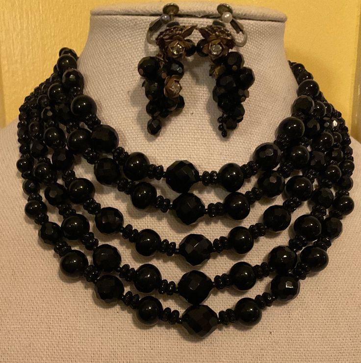 "Up for sale is a 1930's Miriam Haskell 5-Strand Jet Necklace and Earrings made o Grape Vine with Rhinestone and Brass Flowers. Each piece is signed the signature Miriam Haskell Stamp. The set is a Marriage. I acquired them back in the 80's, during the height of collecting Vintage Designer Jewelry. The Necklace has 5-Graduated Strands of Black Jets that are graduated in size as well. The back of the necklace has a brass flower on each end with the Hook and Chain Clasp. The necklace is signed \"Miriam Haskell\" on the back of right brass flower. The earrings are the quintessential Grape Vine Earrings. They too are Black Faceted Jet Glass with 3-Brass and Rhinestone Flowers on each earring. They are the Screw-Spring Back Clip on Earrings. Each Earring is signed on the back of her signature F Victorian Jewelry With Matching Earrings For Evening, Victorian Jewelry With Matching Earrings For Evenings, Victorian Evening Jewelry With Matching Earrings, Antique Jewelry With Round Beads For Vintage Collection, Vintage Round Polished Beads Jewelry, Elegant Polished Bead Jewelry For Evening, Elegant Polished Beads Jewelry For Evening, Art Deco Evening Jewelry With Jewels, Elegant Evening Jewelry With Polished Beads