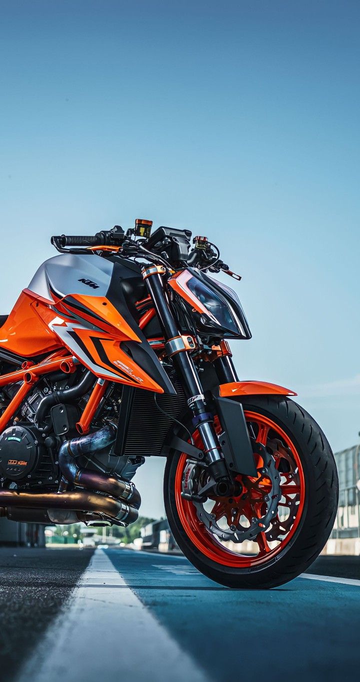 an orange and black motorcycle parked on the street