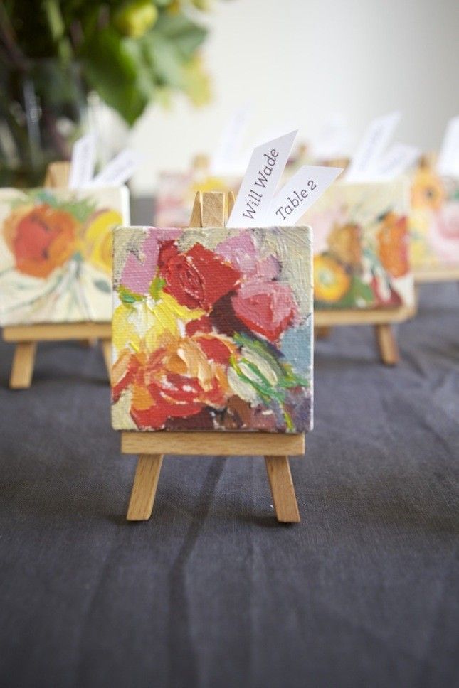 small easels with paintings on them sitting on a table