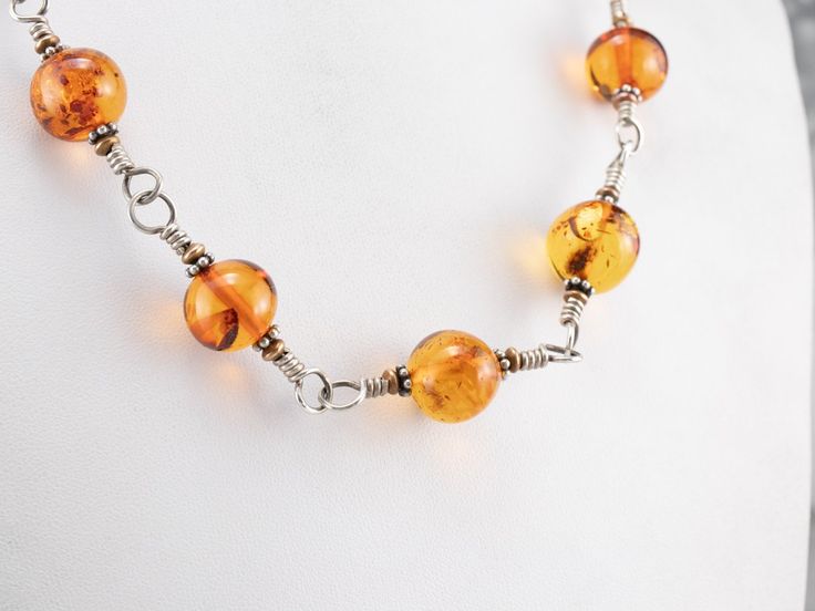 This vintage statement necklace is truly exquisite! Beautiful amber beads are set in between twisting sterling silver wirework, these lovely beads are complemented by simple brass beads. This is a stunning necklace, perfect to dress up or down! Metal: Sterling Silver, Brass Gem: 13 Amber Beads Gem Measurements: 13.5 mm, Round Length: 20 Inches Brass Beads, Cameo Ring, Metal Necklace, Amber Necklace, Amber Beads, Amber Jewelry, Yellow Gold Chain, Stunning Necklace, Metal Necklaces