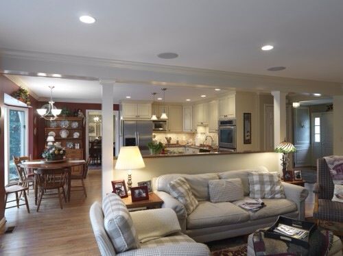 a living room filled with furniture next to a kitchen and dining room table in the background