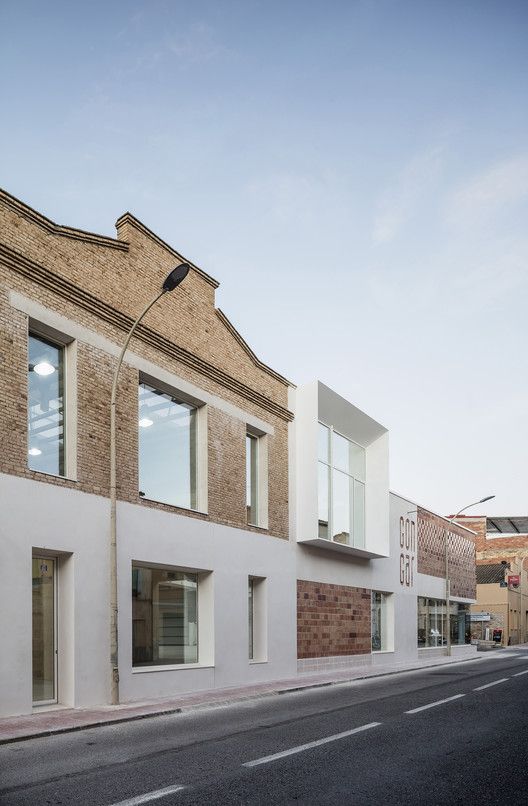 an empty street in front of two buildings with windows on each side and brick walls